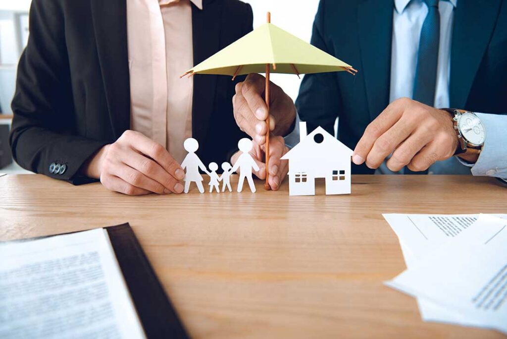 Homeowners review a policy beside a damaged roof, household inventory, and repair documents.